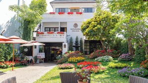 A building with a sign reading "Rachamankha Florahouse" surrounded by a garden with various flowers and plants. - Rachamankha Flora House Chiang Mai (Chiang Mai)