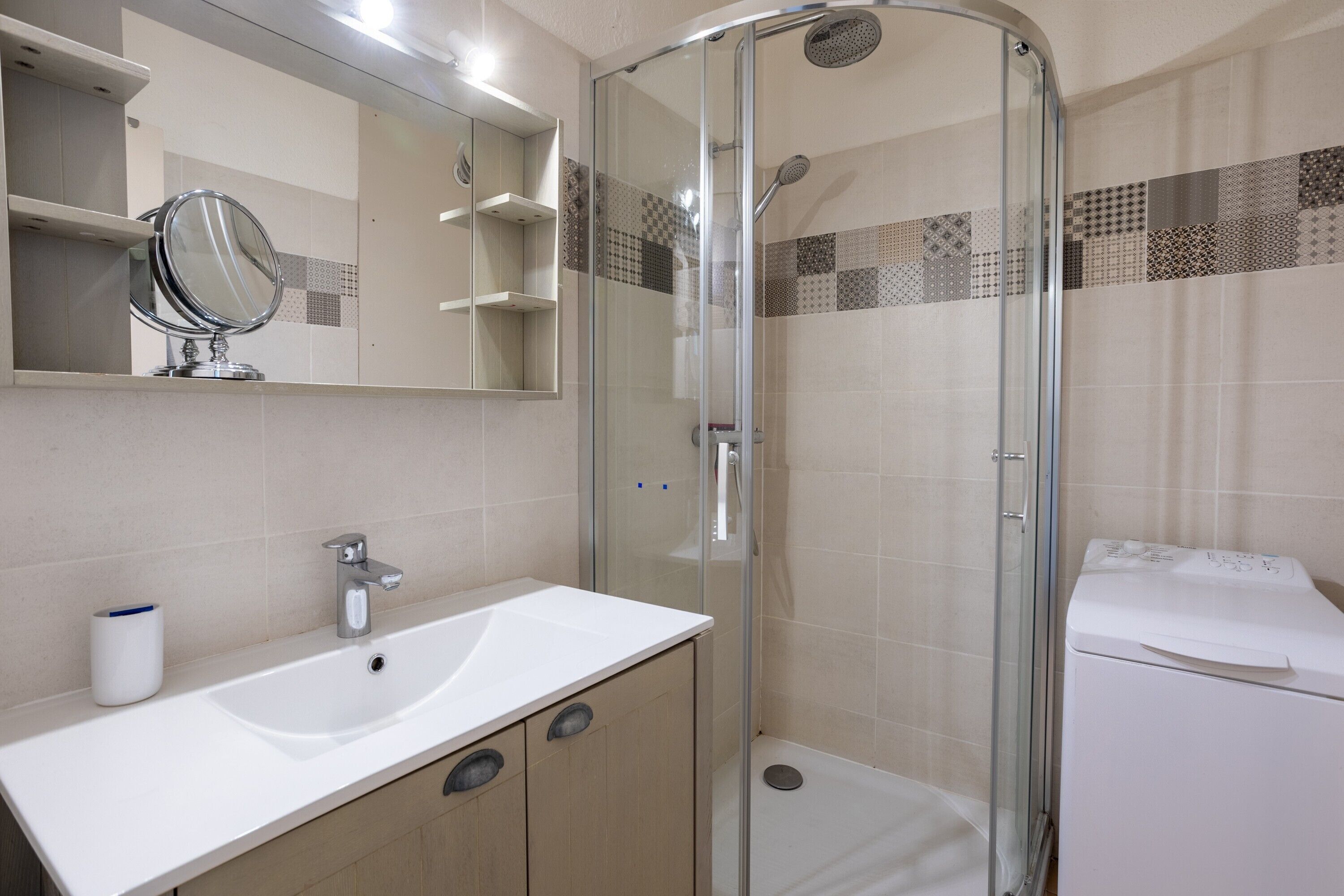 Un bagno con doccia vetrata, lavabo con specchio e servizi igienici.