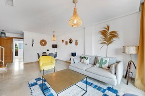 Un salon moderne avec un canapé, une table basse et un fauteuil jaune.
