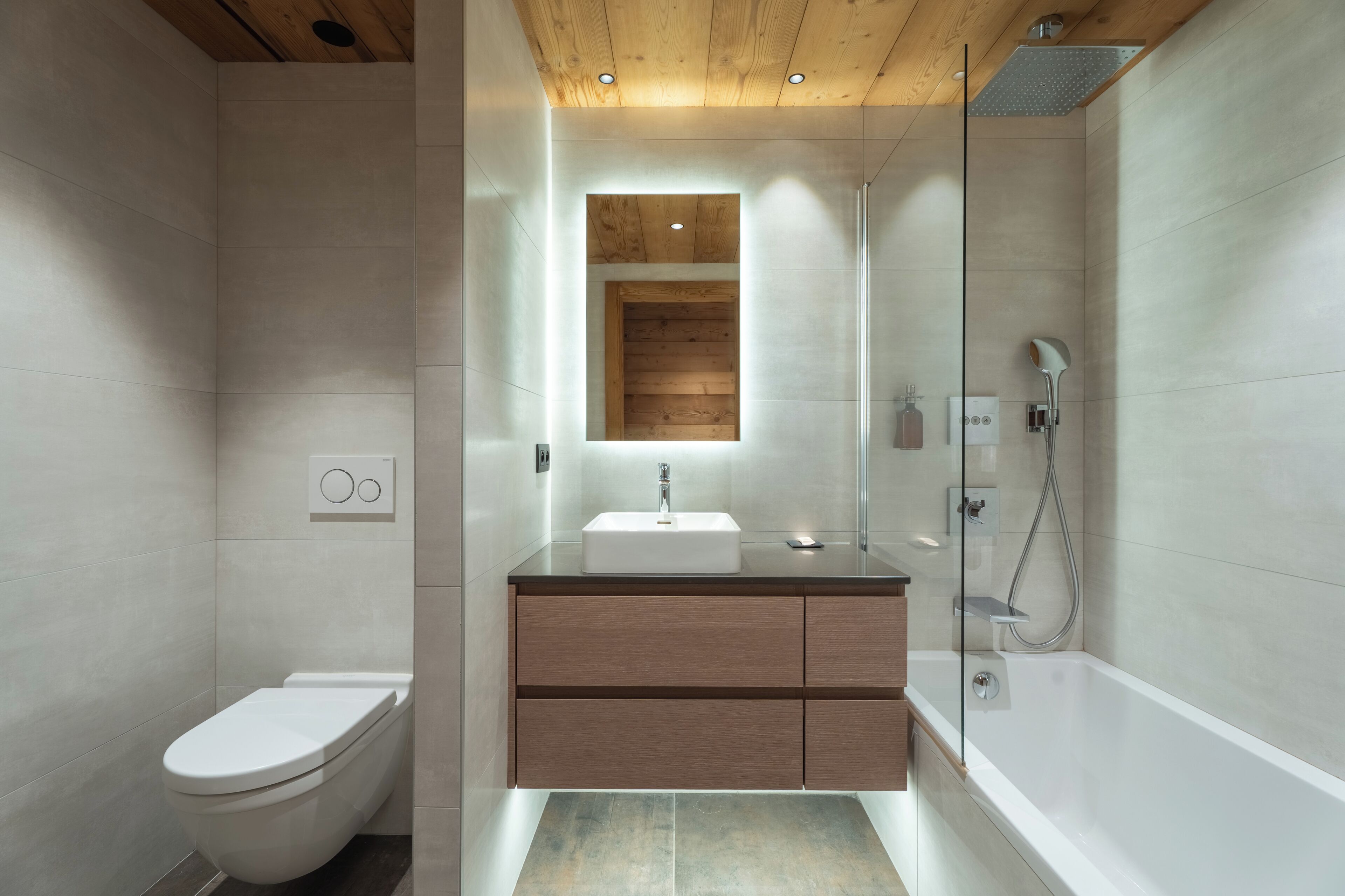 A modern bathroom with a toilet, sink, and shower.