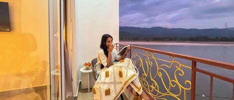 A balcony with a view of a river and mountains.
