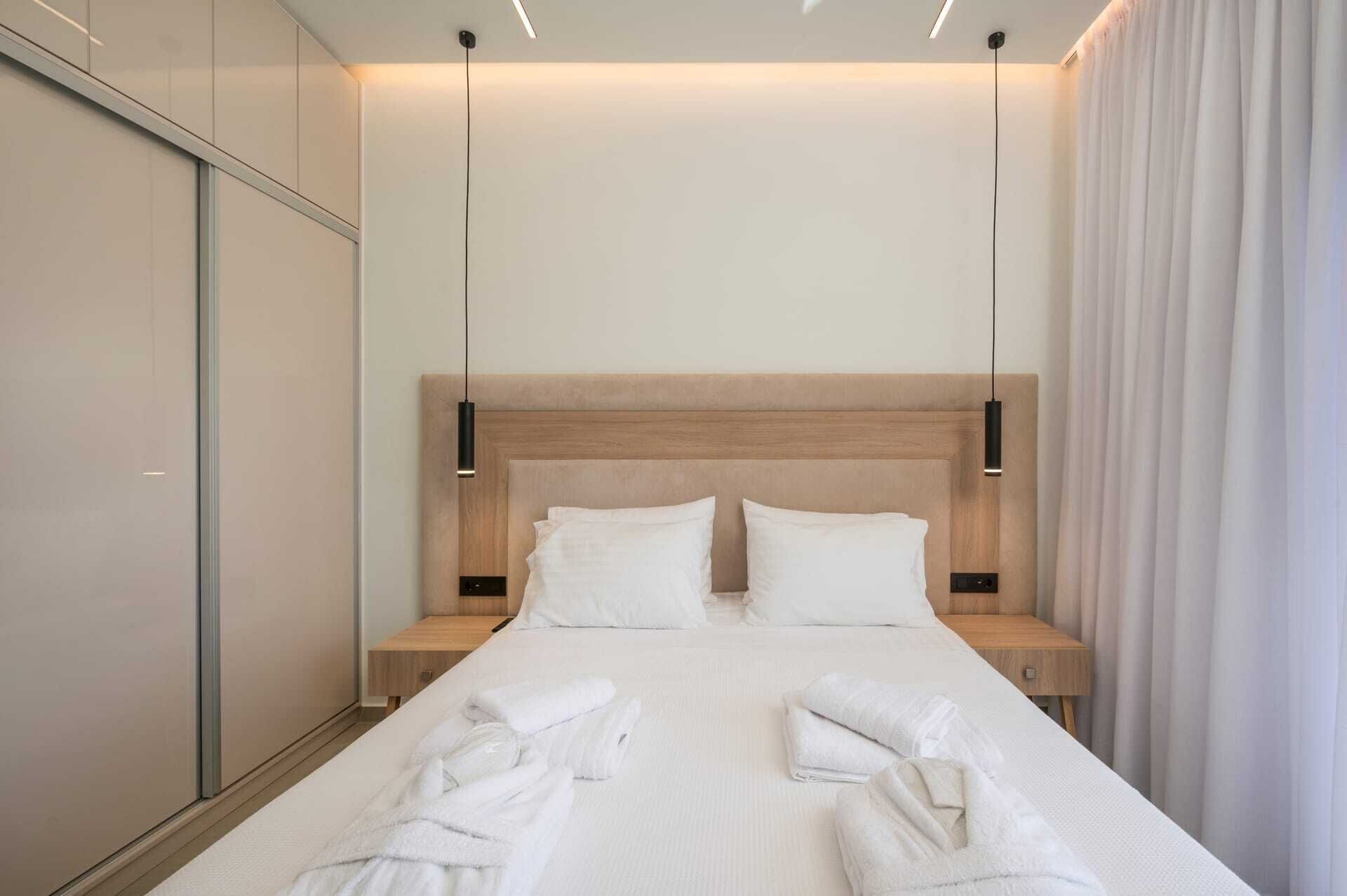 Una camera d'albergo moderna con un letto grande, due comodini e una testiera.