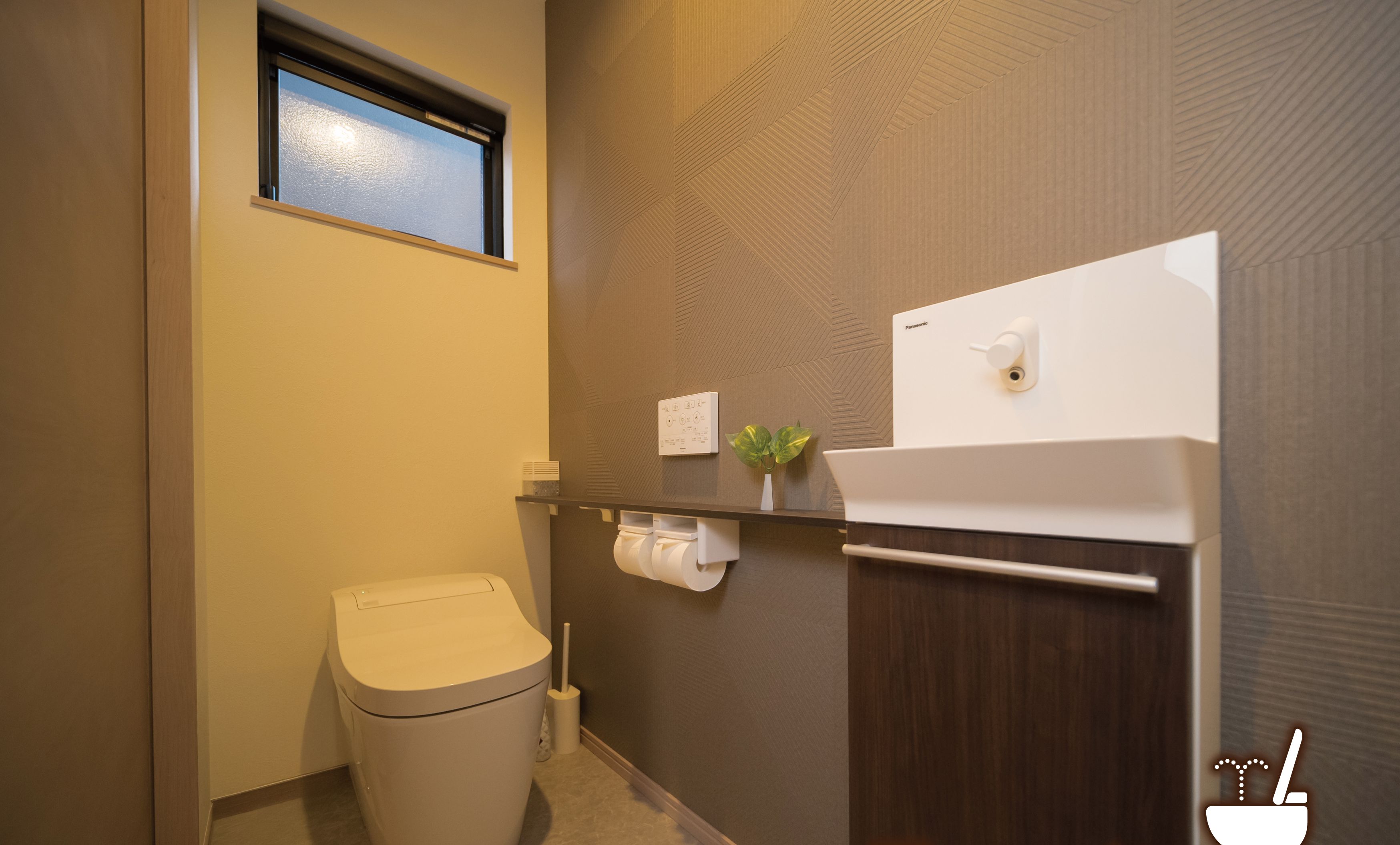 A bathroom with a toilet, a sink, and a window.