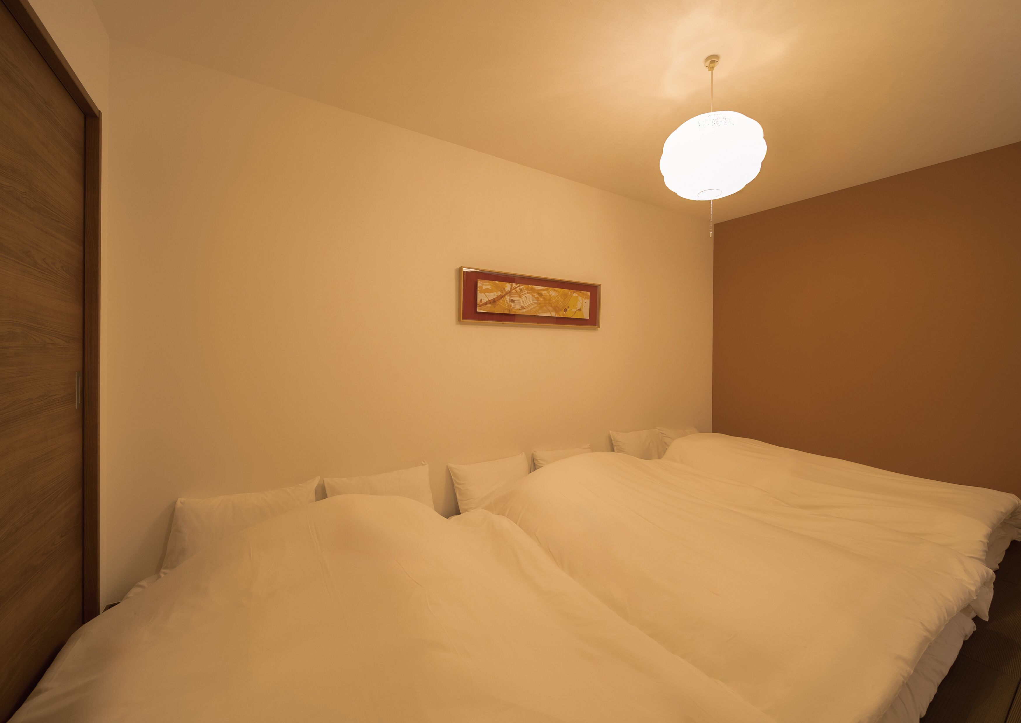 Un dormitorio con una cama grande, un armario de madera y una lámpara en el techo.