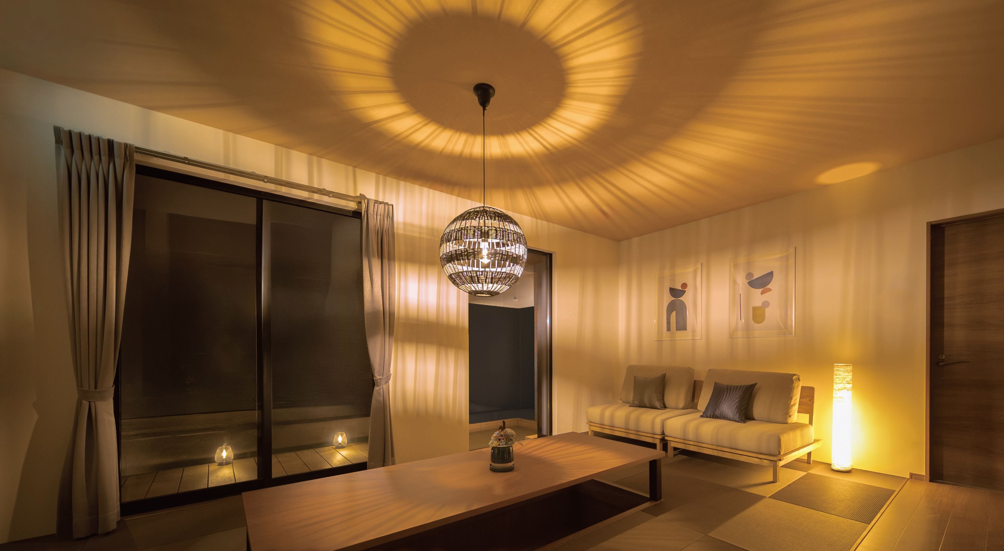 Un salon spacieux, doté d’un grand canapé, d’une table basse et d’un lustre original.