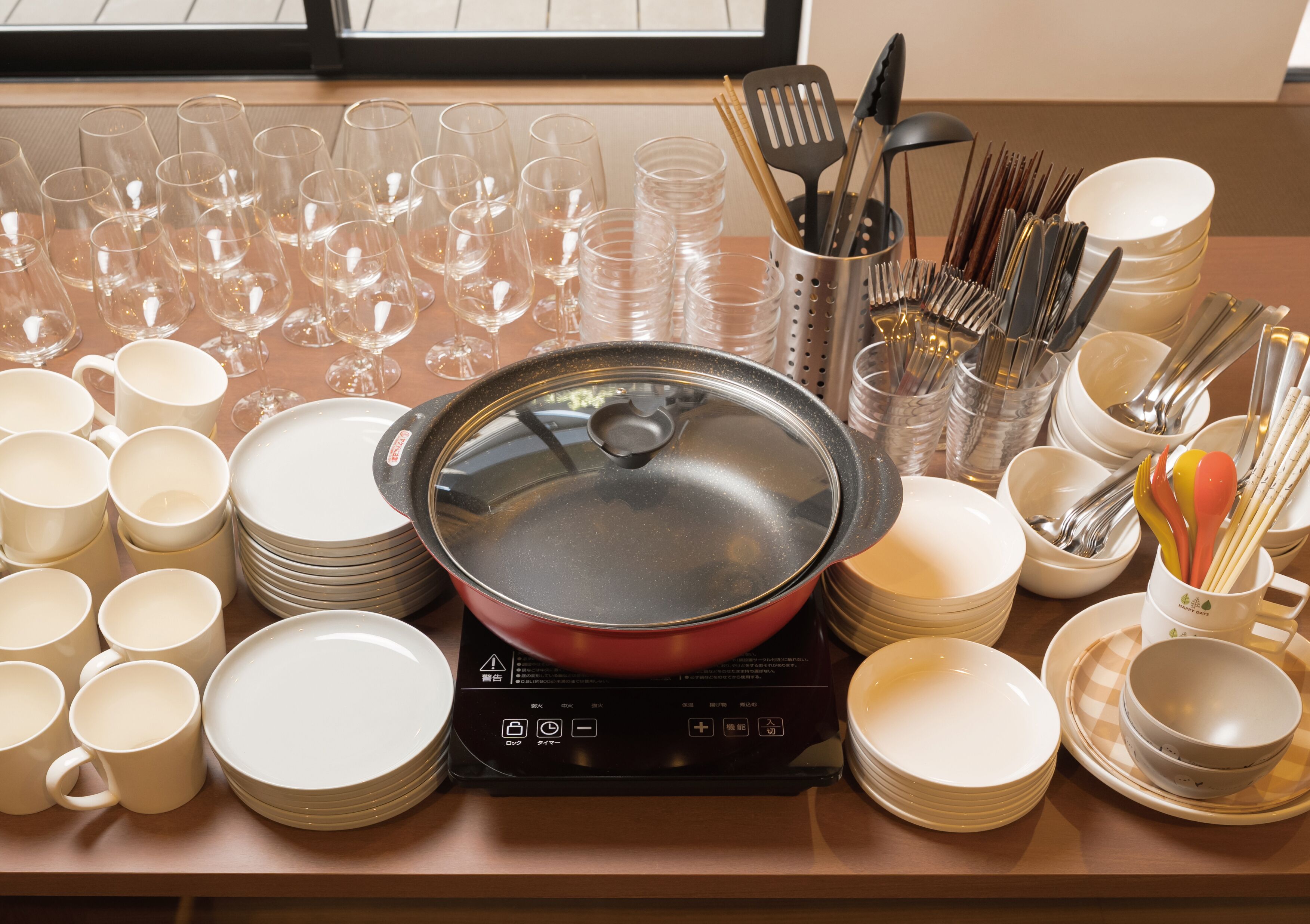 A kitchen counter with various dishes, glasses, and utensils.