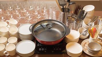 A kitchen counter with various dishes, glasses, and utensils.