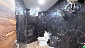 A modern bathroom with a toilet, sink, and shower. - Roomshala J S Garden (Noida)