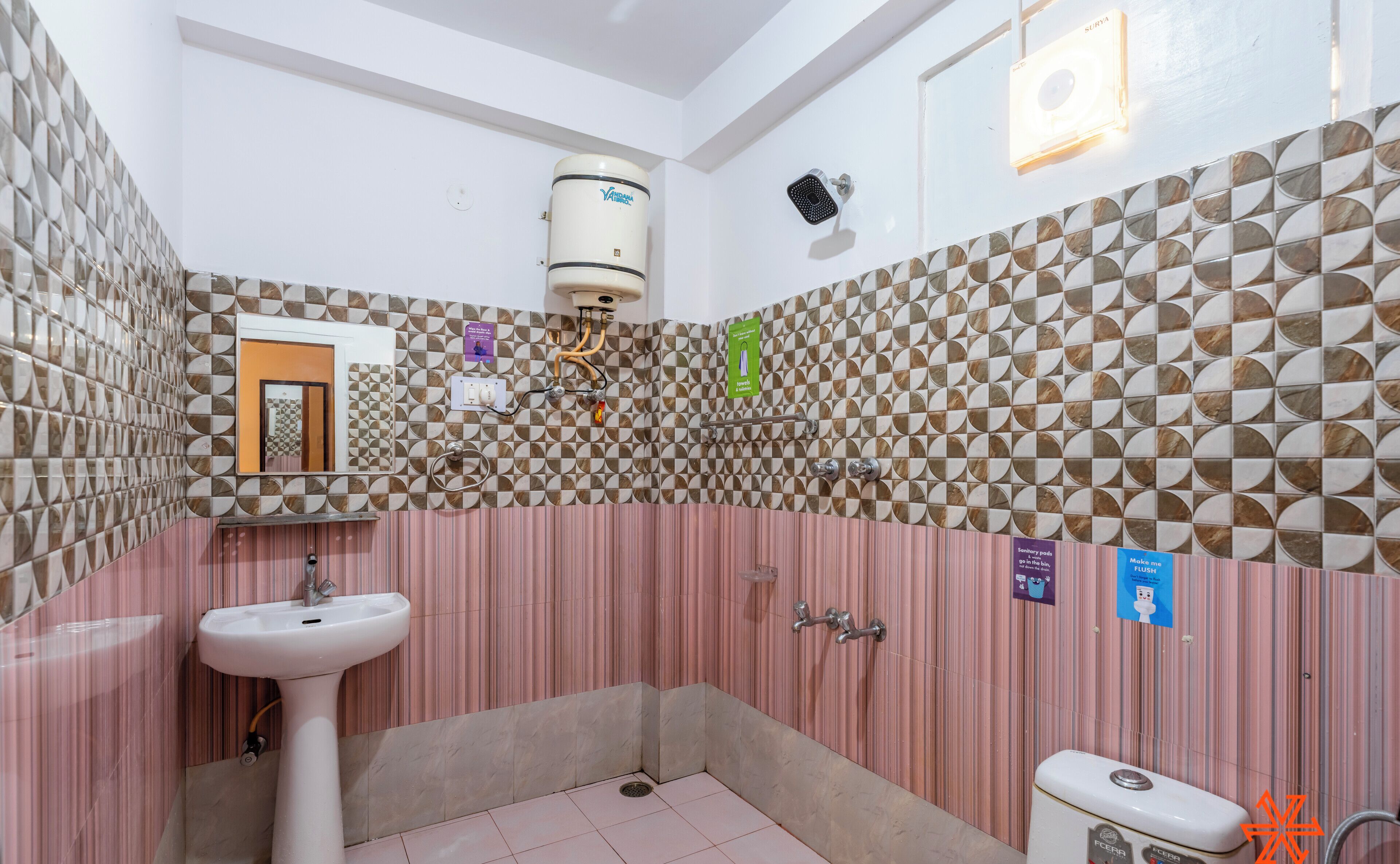 Ein Badezimmer mit Waschbecken, Toilette, Dusche und einer Wand mit Muster.