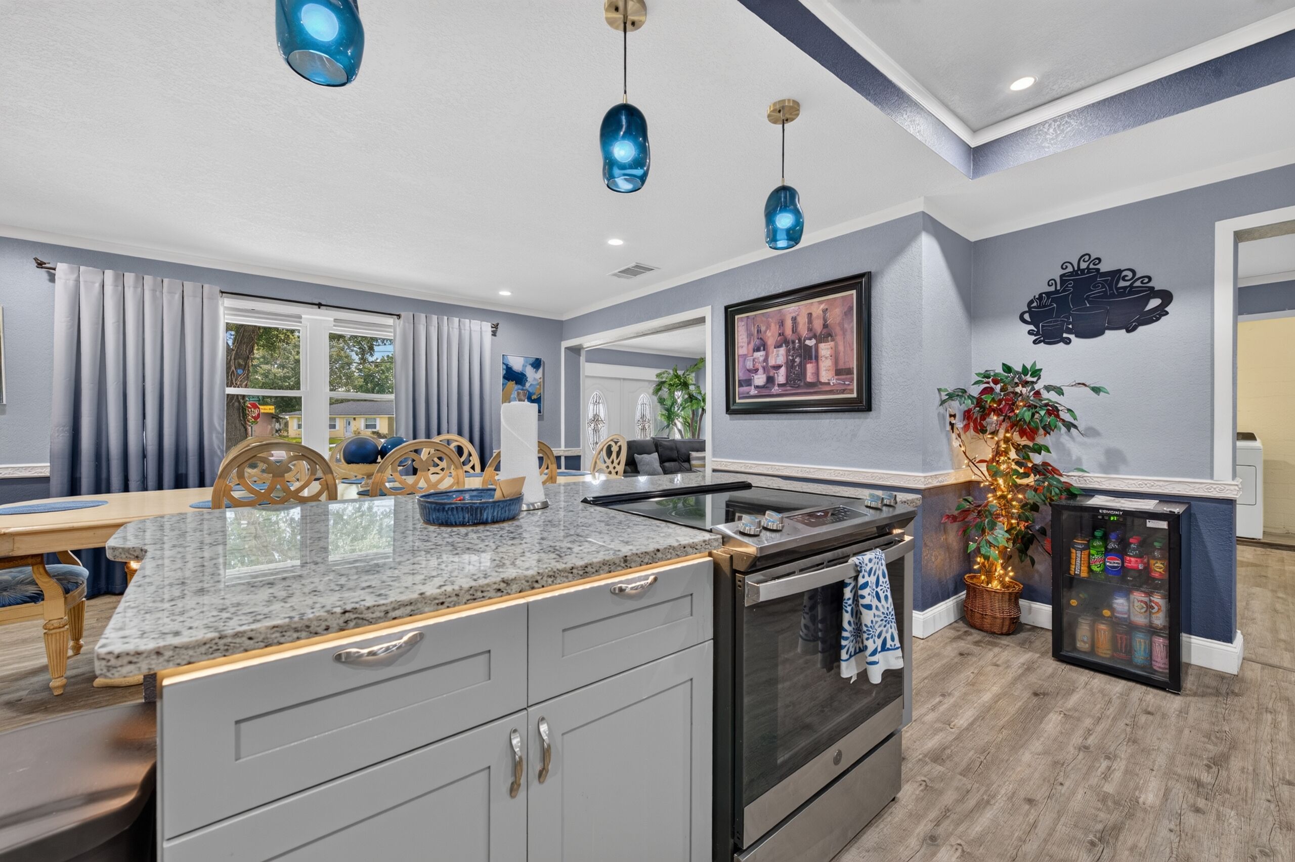 A modern kitchen with granite countertops, stainless steel appliances, and pendant lighting.