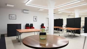 A conference room with tables, chairs, and a central table with a decorative vase.