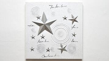 A white wall with a textured pattern and several stars of varying sizes.