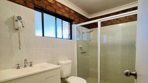 Ein Badezimmer mit Waschbecken, Toilette und einer Duschkabine.