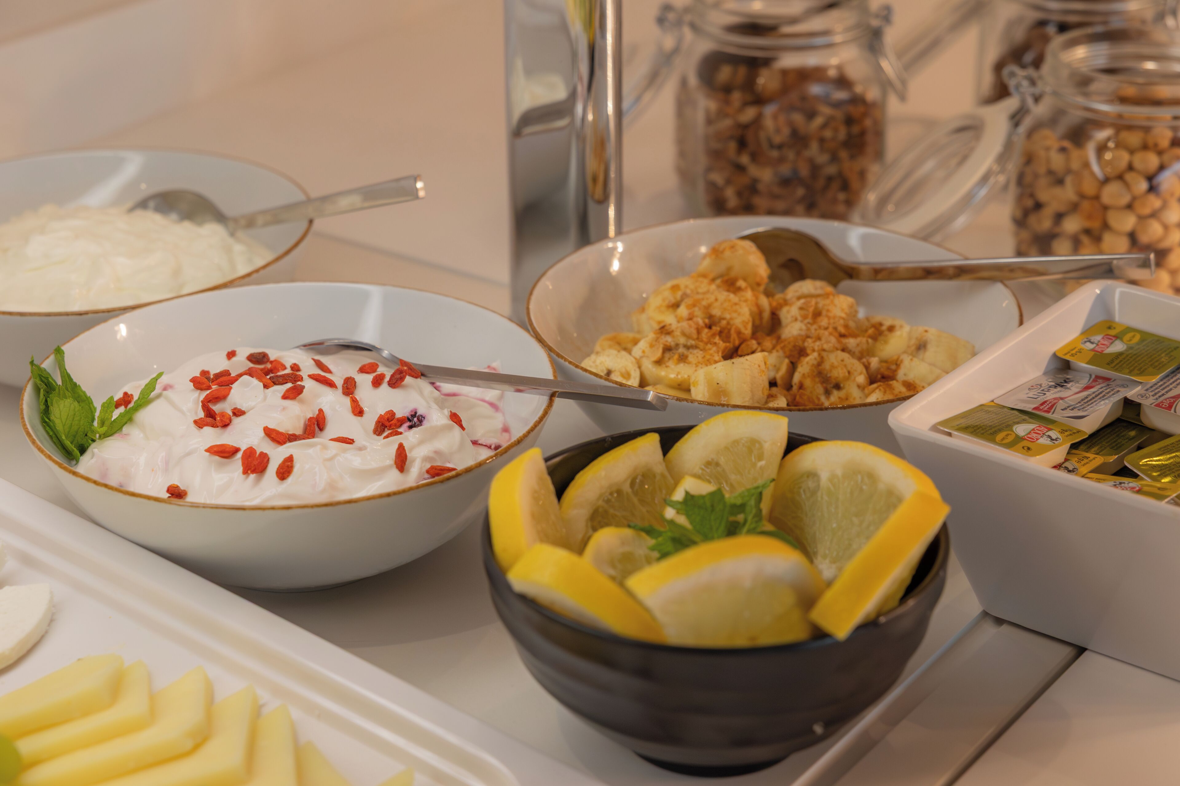 Un buffet proposant une variété d’aliments, notamment des yaourts, des fruits et des noix.