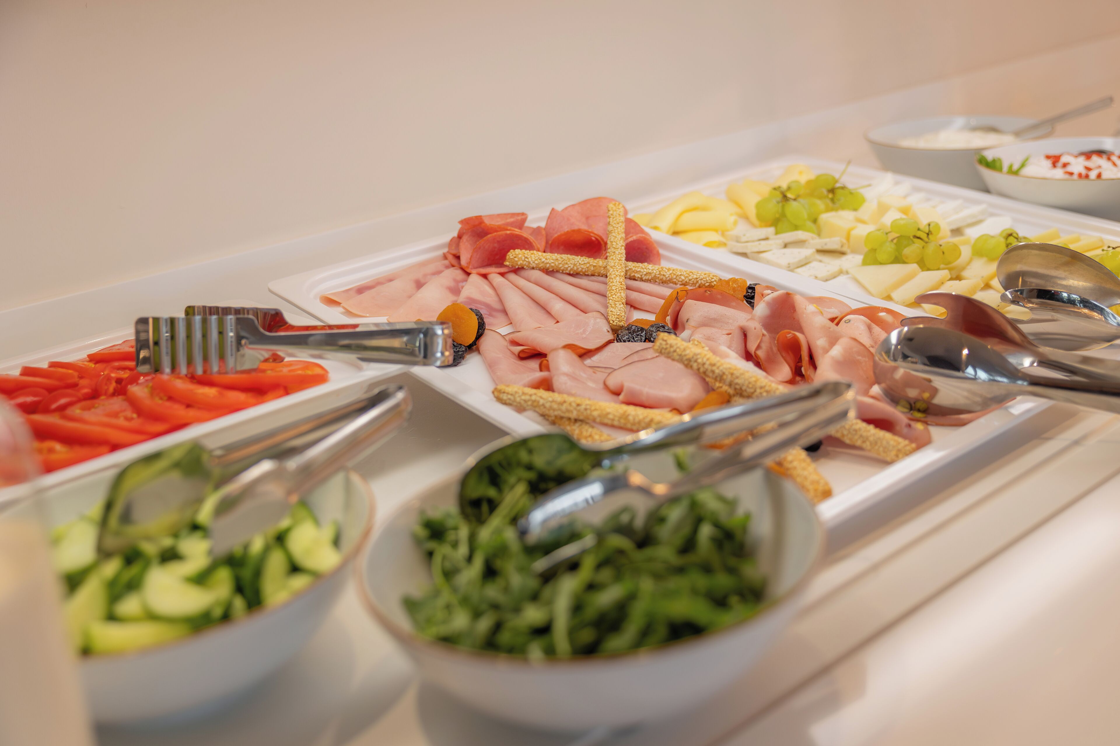 Un buffet proposant une variété de plats, notamment des viandes, des fromages et des légumes.