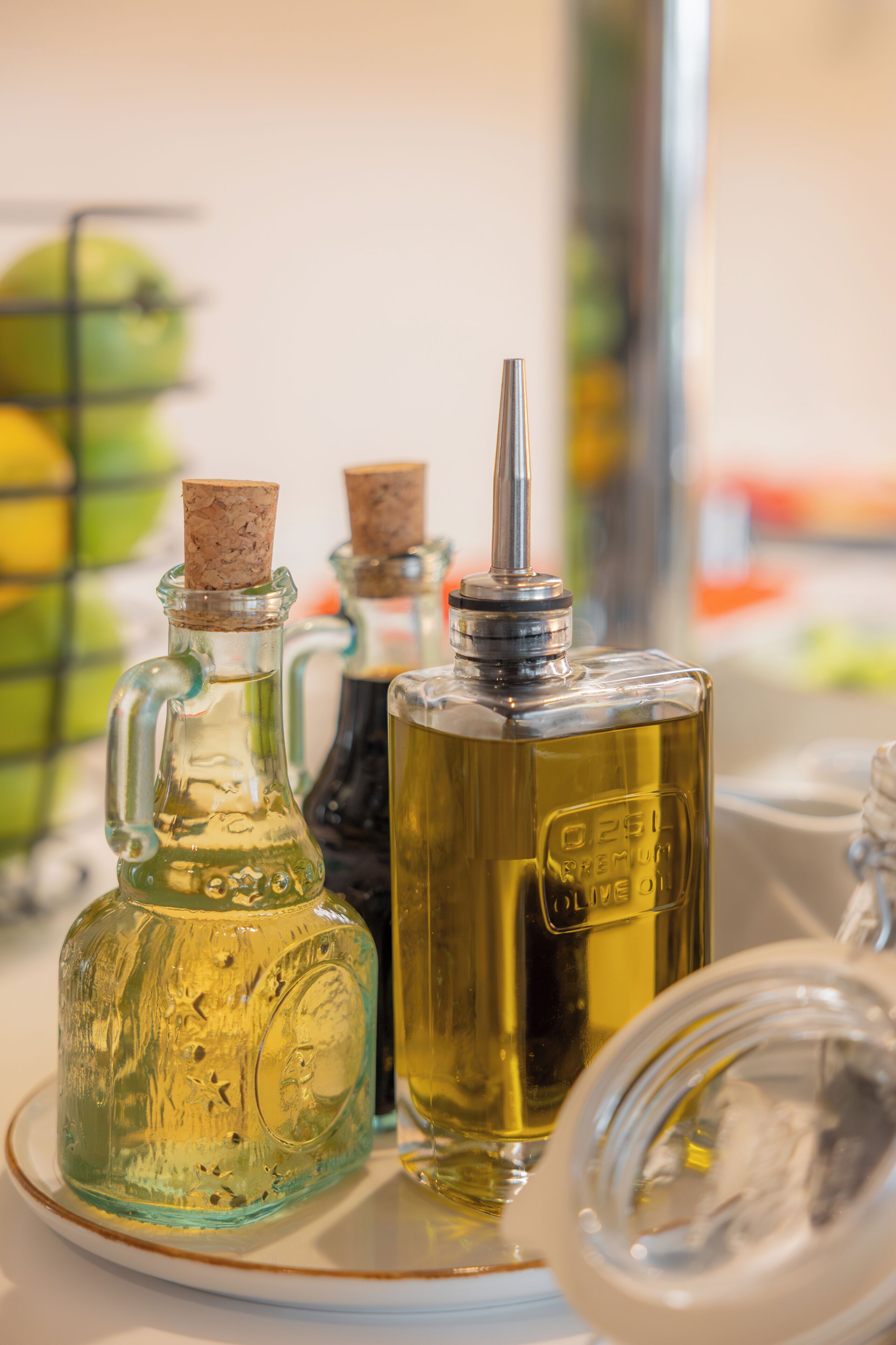 Three glass bottles with cork stoppers on a white tray.