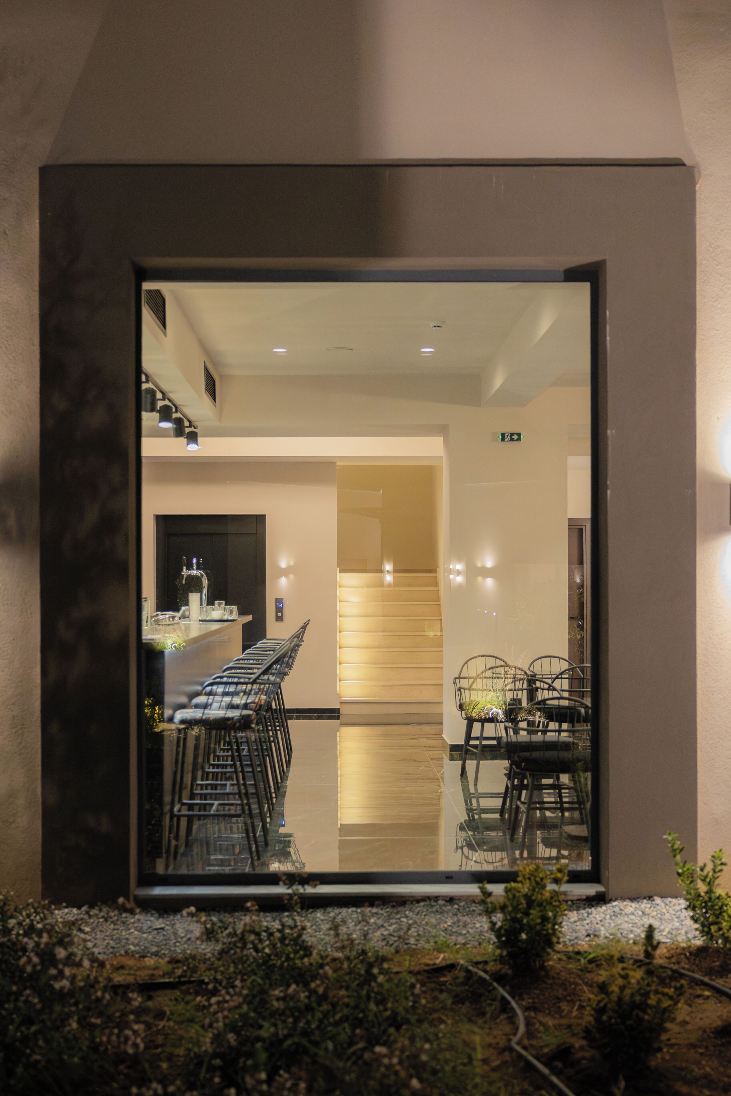 Un intérieur moderne comprenant un coin repas, un escalier et un comptoir d’accueil.