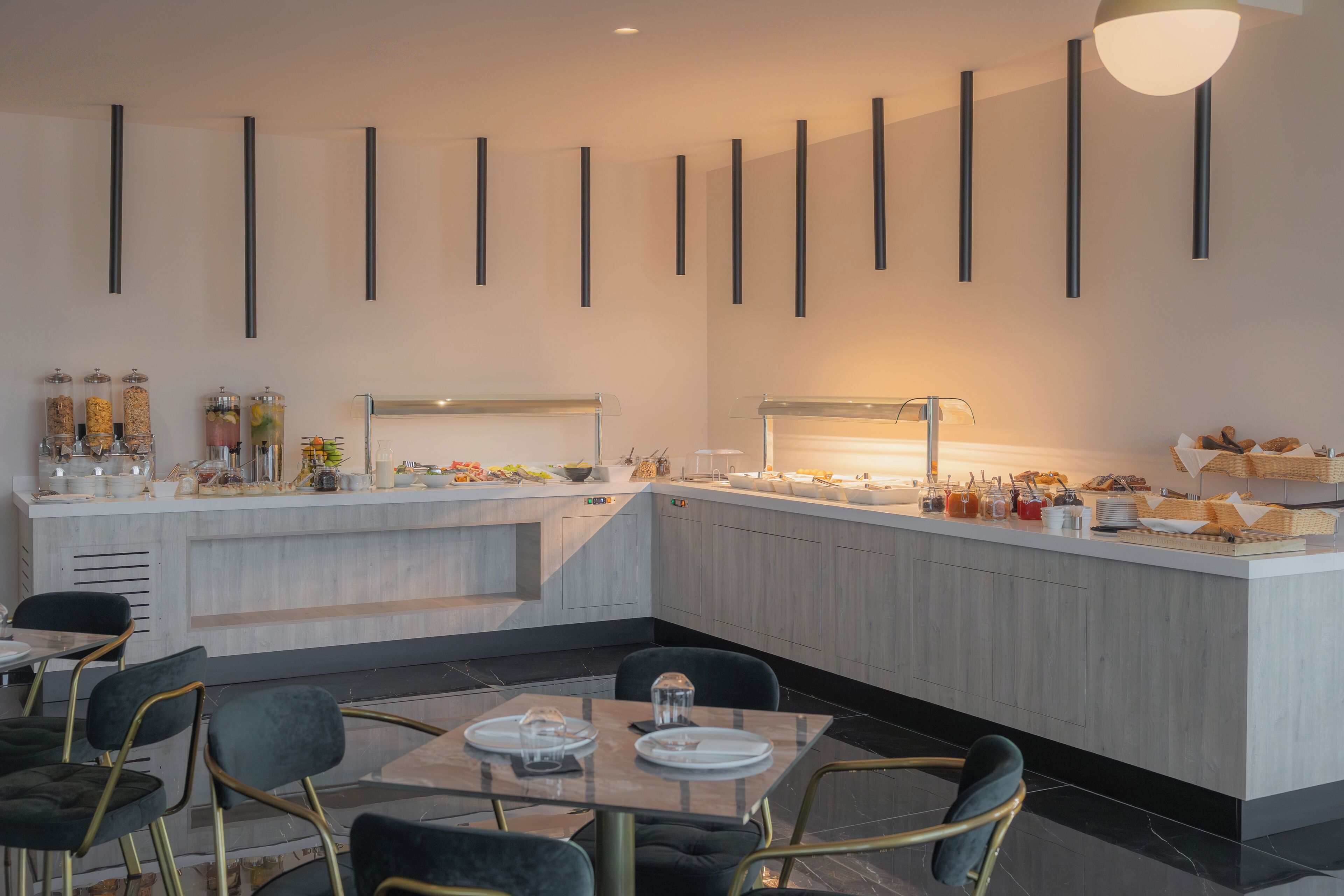 Un área de comedor moderna con una isla central, sillas negras y una mesa blanca.