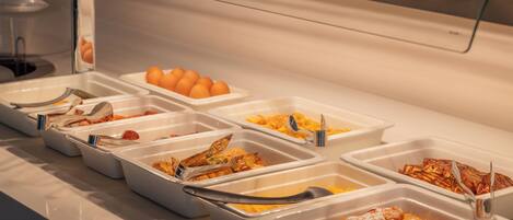 A buffet with various food options, including eggs, scrambled eggs, and other dishes.