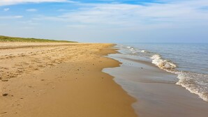 A beach with a sandy shore and gentle waves. - Ballygarrett Holiday Home (Cahore)