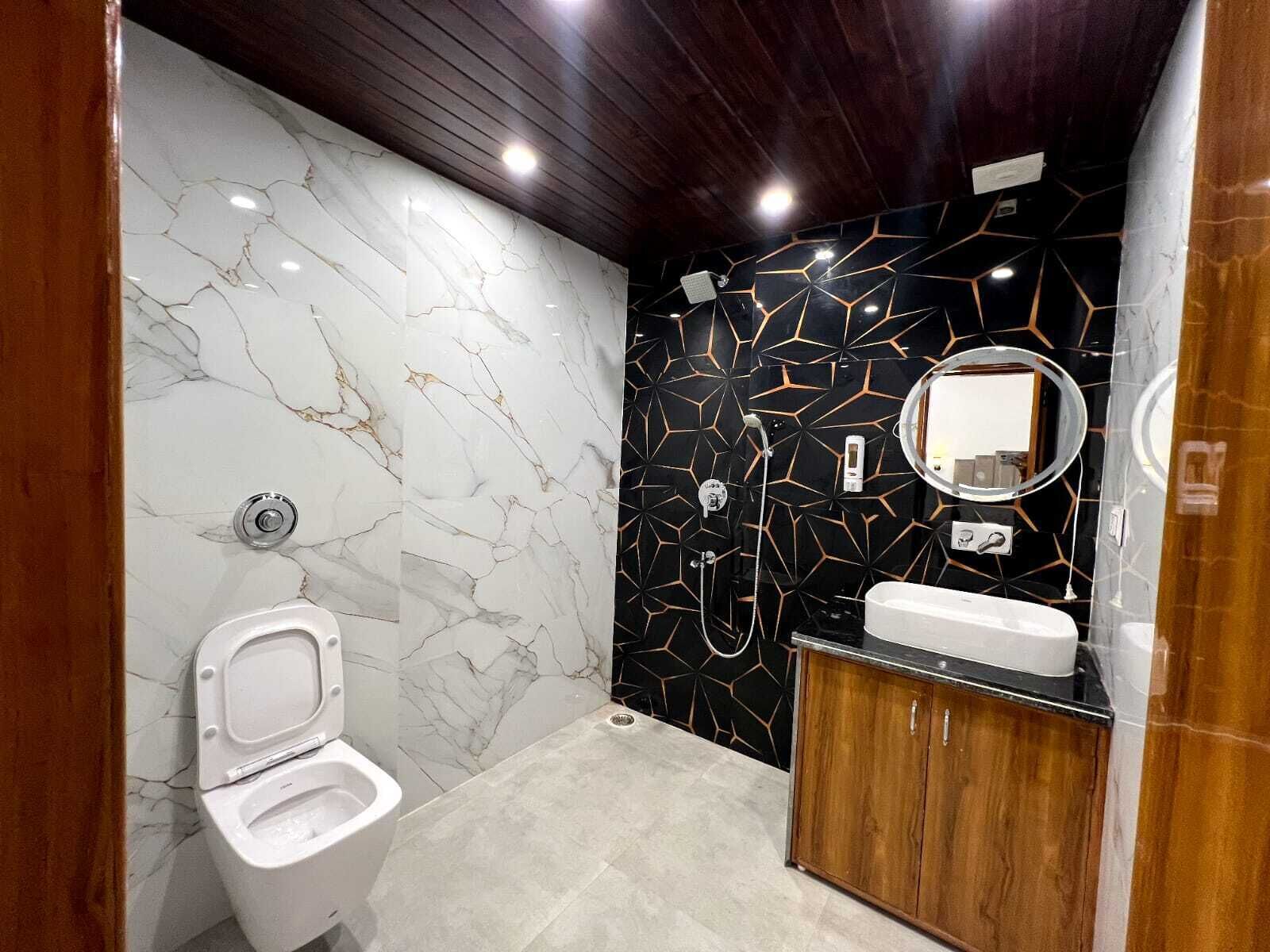 A modern bathroom with a marble vanity, a toilet, and a shower area.
