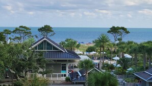 A beachfront property with a prominent building featuring a triangular roof, a balcony, and a view of the ocean. - Ocean Oak by Hilton Grand Vacations: Your 2-Bedroom Coastal Haven (Hilton Head Island)