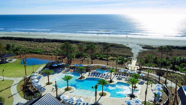 A resort with multiple swimming pools, beach access, and a view of the ocean. - Ocean Oak by Hilton Grand Vacations: Your 2-Bedroom Coastal Haven (Hilton Head Island)