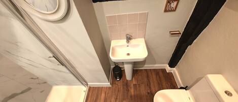 A bathroom with a white sink, a toilet, and a mirror.