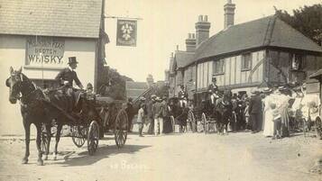 A historical street scene with a horse-drawn carriage, buildings, and a sign for 'Mountain Peak Scotch Whisky'.