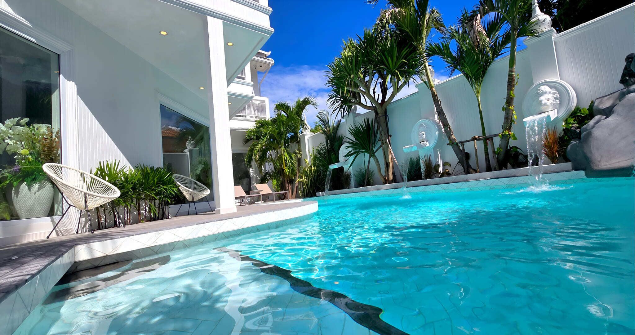 Una piscina al aire libre, sillones reclinables de piscina