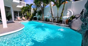 Una piscina al aire libre, tumbonas