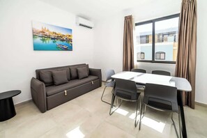 TV - Bright Triple Studio Apartment with Balcony by HostMT (San Pawl il-Baħar)