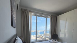 Una habitación de hotel con una cama grande, vistas al mar y una lámpara en el techo.