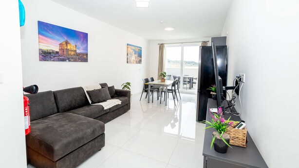 Een moderne woonkamer met een hoekbank, een eethoek en een balkon met uitzicht.