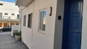 A building with a blue door, a small window, and a potted plant. - Comfortable 3-Bedroom Seaside Stay (St. Paul's Bay)
