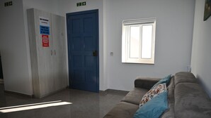 A room with a blue door, a window, a couch, and a sign on the wall. - Comfortable 3-Bedroom Seaside Stay (St. Paul's Bay)