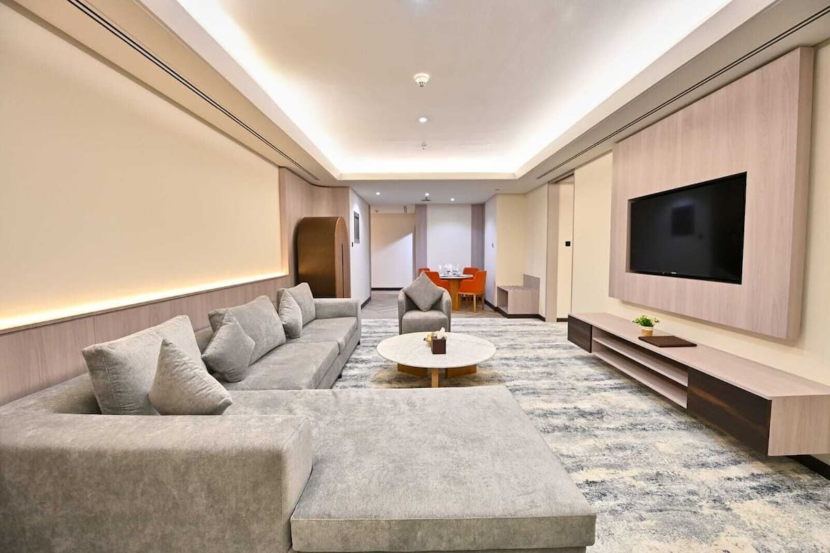 A modern living room with a sofa, coffee table, and TV.