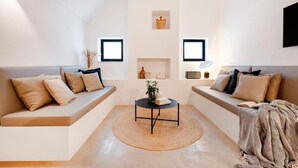 A modern living room with a sofa set, a coffee table, and decorative items on the walls.