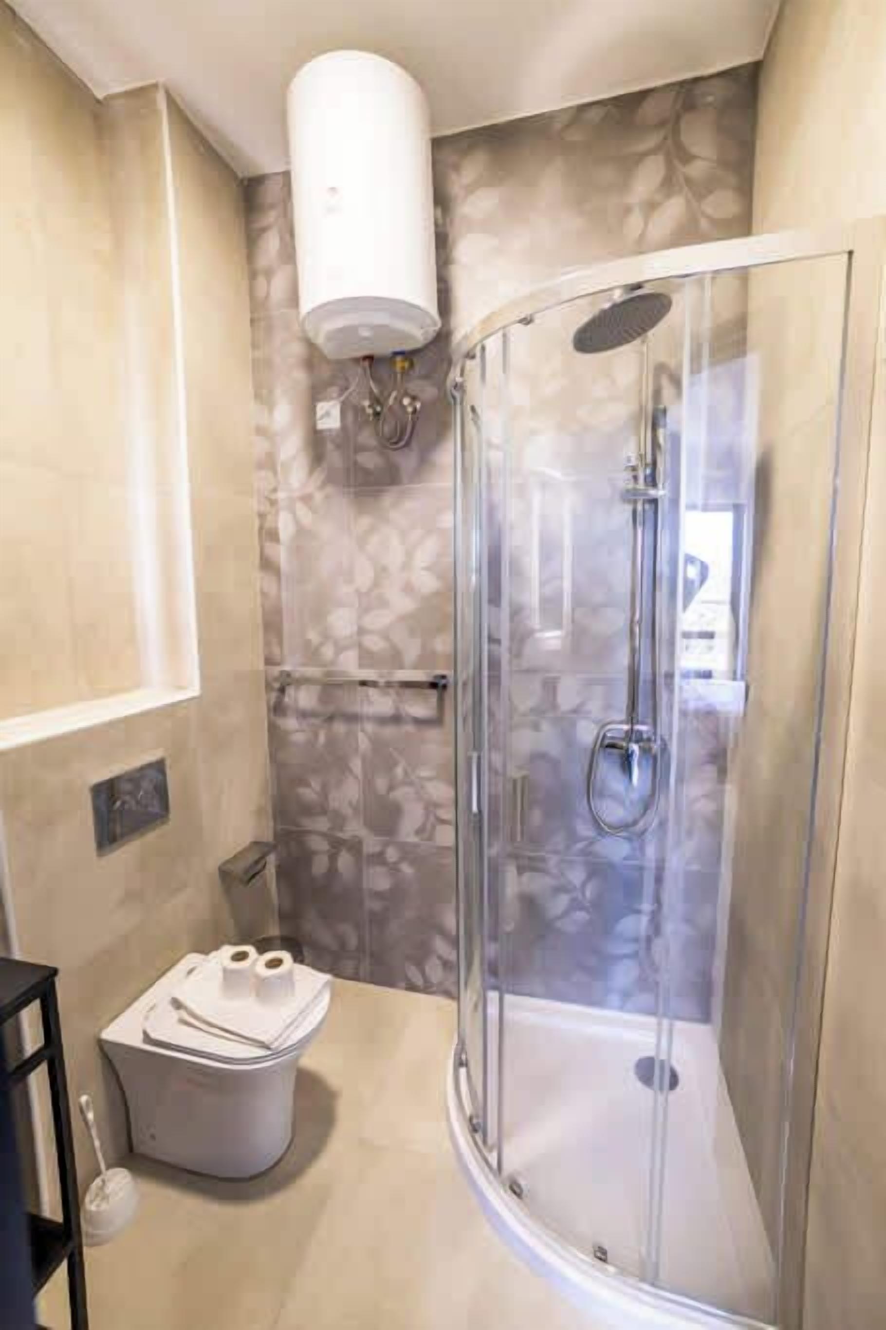 Un bagno moderno con box doccia in vetro, un water con funzione bidet e un termosifone a parete.