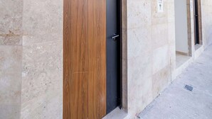 Un bâtiment moderne doté de larges murs en pierre et d’une série de portes.