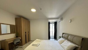 A hotel room with a bed, a desk, and a chair.