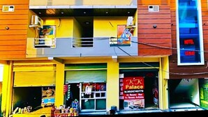 A two-story building with a yellow facade and a sign advertising "KK Palace" with available rooms. - HOTEL K K PALACE (Khatoo)