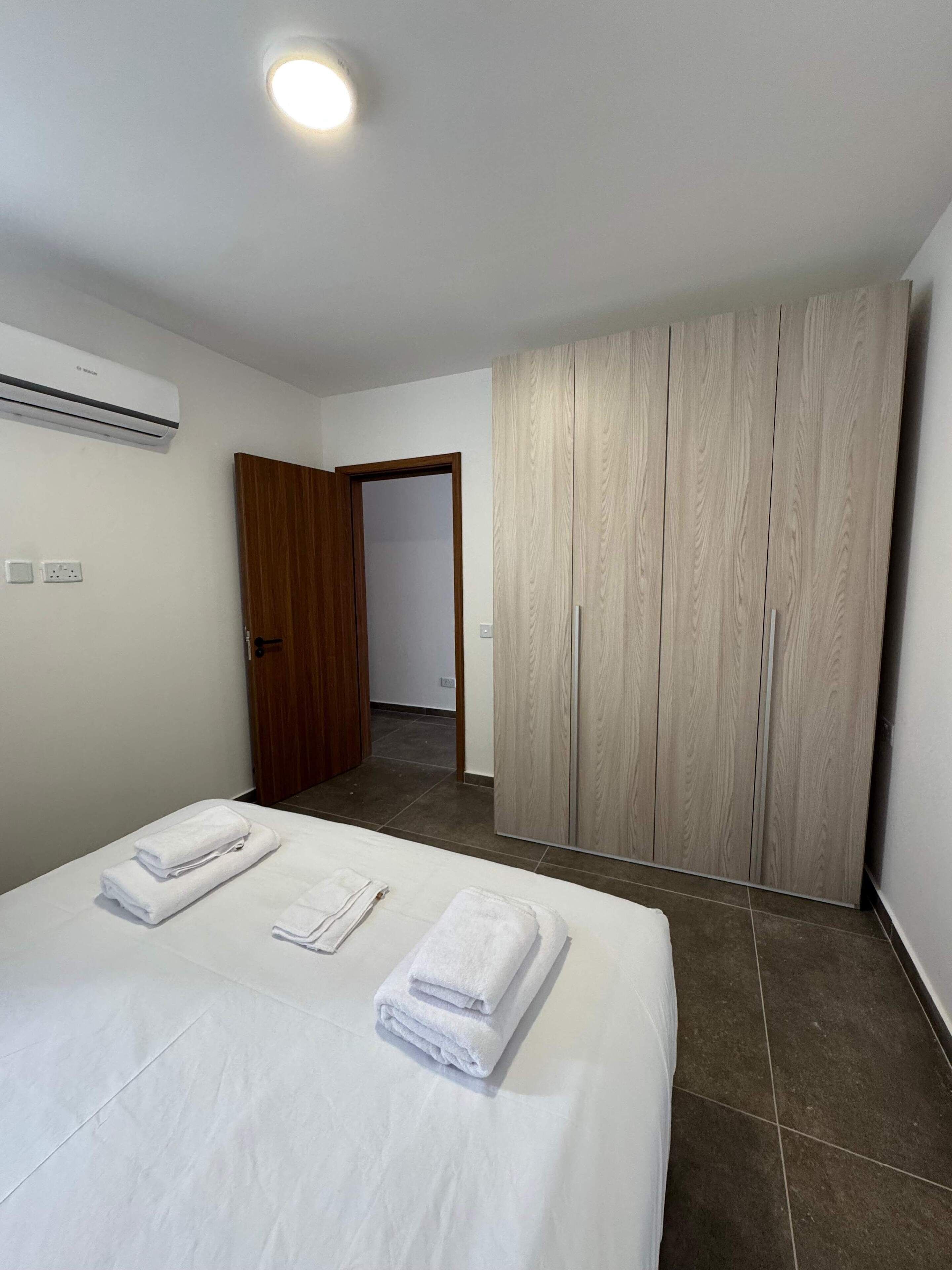 Een hotelkamer met een bed, een kledingkast en een airconditioning.