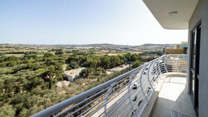 A balcony with a view of a rural landscape, including fields and trees. - Modern Studio with Double Bed & Kitchen by HostMT (San Pawl il-Baħar)