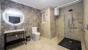Ein modernes Badezimmer mit Toilette, Waschbecken und Dusche.