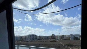 En balkon med udsigt over bybilledet, inklusive bygninger og en klar himmel.