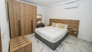 Ein Hotelzimmer mit einem großen Bett, einem Holzschrank, einem Schreibtisch und einem Stuhl.