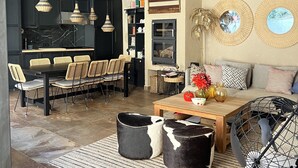A spacious living area with a dining set, a sofa, and a coffee table. There are hanging lights and a fireplace. - Rural House La Real de Guadalupe (Guadalupe)