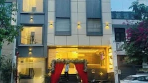 A multi-story building with a modern design, featuring a prominent entrance with a red archway and a staircase leading up to it. - Hotel AU Villa (Etmadpur)