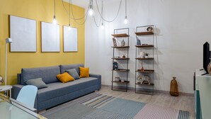 Uma sala de estar moderna com um sofá azul, paredes amarelas e um tapete listrado.